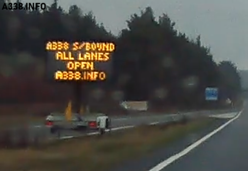 Portable Variable Message Sign with the text 'A338 S/BOUND ALL LANES OPEN A338.INFO'. The sign is situated alongside the main carriageway of the A338 Spur Road between Ashley Heath roundabout and Blackwater Junction.